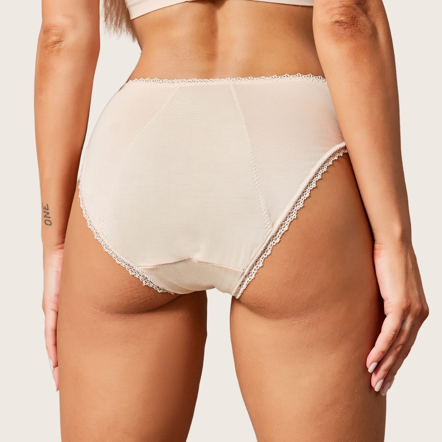 Vue arrière de la culotte menstruelle en dentelle fine sur les côtés, couleur nude