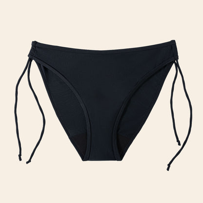 Vue produit à plat du bas de maillot de bain menstruel bikini liberté avec ficelles réglables et à nouer sur les côtés, couleur noire
